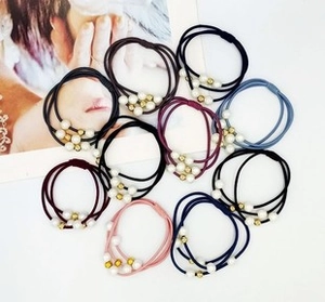 Detail of high-elastic multi-strand hair ties with elegant faux pearls and gold beads