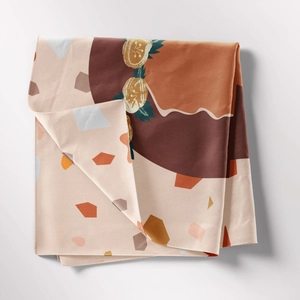 Macro shot of folded bohemian tapestry with geometric earthy tones and citrus patterns