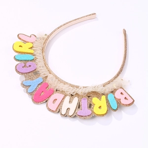 Detail of colorful 'BIRTHDAY GIRL' felt letters and gold glitter headband with beige mesh trim
