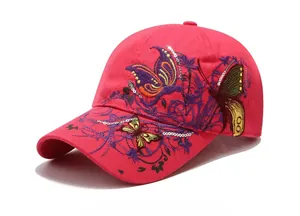 Dettaglio del cappellino rosa acceso con ricamo a farfalla di paillettes e decorazioni