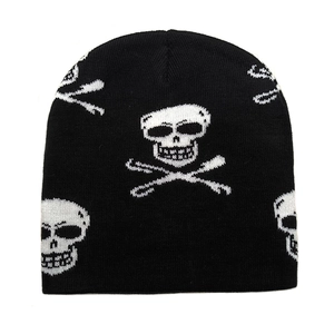 Close-up of black knitted beanie featuring white skull and crossbones jacquard pattern