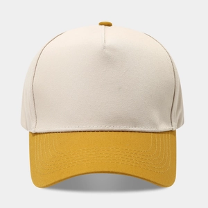 Detail of five-panel baseball cap showing beige crown and yellow visor with stitching
