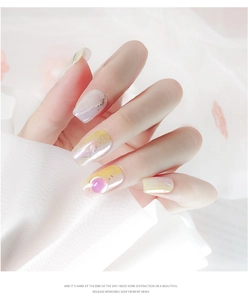 Macro detail of aurora gradient nail art with gold foil flakes and pink circular decor