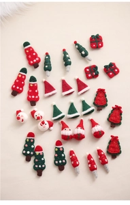 Detailed view of handmade Christmas wool felt ornaments including trees and Santa heads