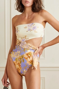 Detail of floral one-piece swimsuit featuring waist cut-out and lace-up strap design