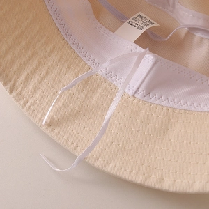 Detail view of cotton sun hat interior with sweatband, adjustable drawstring and care label