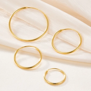 Polished gold 925 sterling silver hoop earrings in four sizes on silk fabric