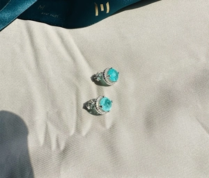 Macro detail of 925 sterling silver stud earring featuring round Paraiba gemstone