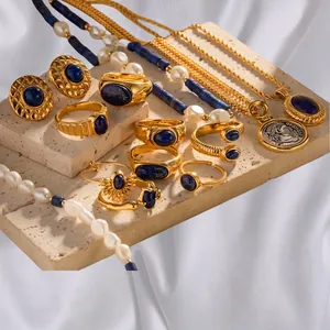 Vintage gold jewelry set with lapis lazuli and pearls displayed on white silk fabric
