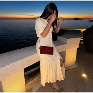 Kurzärmeliges Strickkleid mit Knöpfen in Creme, schicker Handtasche und hohen Schuhen