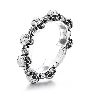 Punk style stainless steel bracelet featuring skull beads and detailed floral engravings