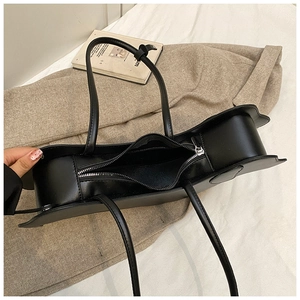 Top view of black leather tote bag showing spacious interior and smooth zipper closure