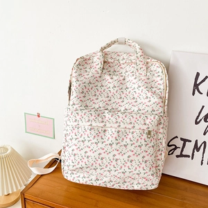Detailed view of floral canvas backpack on wooden surface with minimalist decor background