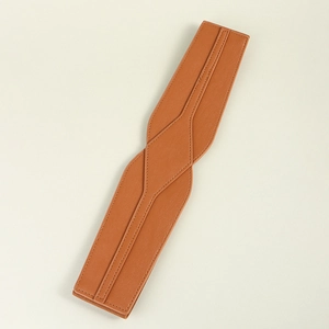Detailed view of a brown leather waist belt with fine stitching on a clean beige background