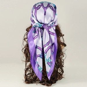 Detail of silk-like satin square scarf with purple chain and belt print on hair
