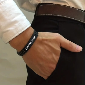 Close-up of black stainless steel watch strap bracelet on wrist with custom logo plaque