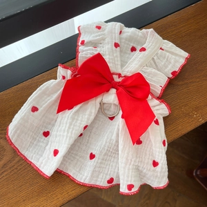 Detail of white cotton dog dress with red hearts, silk bow and metal D-ring leash attachment