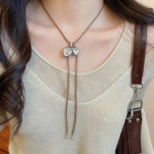 Close-up of double heart zircon pendant with brown adjustable leather rope cord
