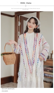 Dettaglio del cardigan in maglia all'uncinetto bianco con bordi colorati e traforati