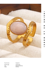 Detail of an 18K gold plated ring featuring a pink oval gemstone on white canvas padding