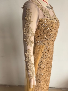 Vue détaillée des appliques de dentelle dorée et des paillettes sur la robe de soirée