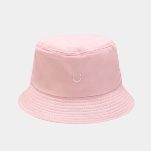 Close-up of pink bucket hat with white smile embroidery and fine stitching detail