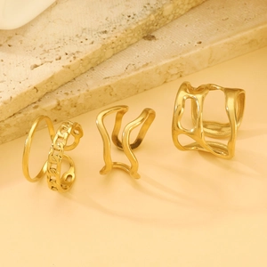 Detailed view of irregular liquid gold rings set displayed on a natural stone surface