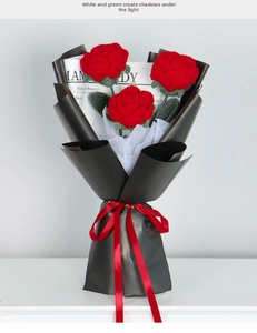 Detailed view of a hand-knitted red rose bouquet with black wrapping and red ribbon