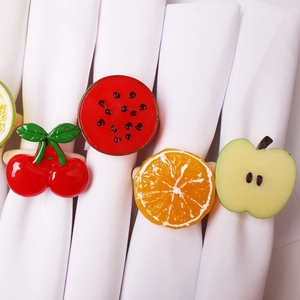 Detailed close-up of realistic faux fruit napkin rings featuring cherry and watermelon