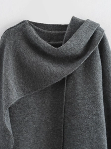 Dettaglio ravvicinato della trama in maglia grigio scuro e del collo a strati del poncho
