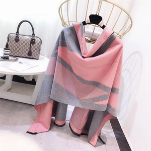 Pink and grey geometric wave scarf draped over a gold chair in a bright, stylish room