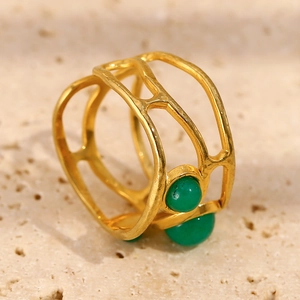 Macro detail of 18K gold plated multi-layer镂空 ring featuring green round stone inlay