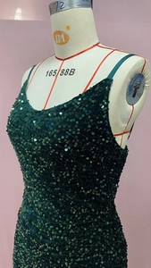 Gros plan des paillettes vert foncé sur une robe de soirée à col en V avec bretelles