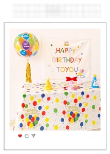 Detail of colorful birthday party decor set with balloons, banner and tablecloth