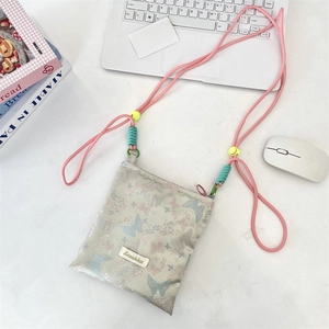 Detail of colorful butterfly jacquard bag with pink rope strap and smiley bead