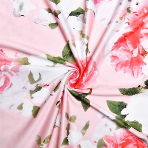 Close-up of pink fabric featuring red roses and green leaves in a spiral fold design