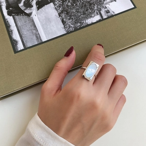 Detailed view of an oval shell inlay ring on model finger with S925 silver band