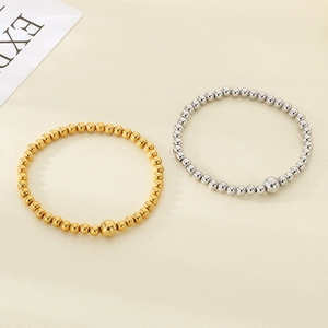 Close-up of 18K gold and silver stainless steel beaded bracelets with larger center bead