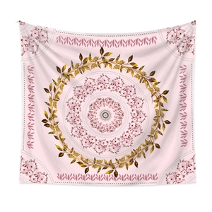 Detailed close-up of pink floral mandala tapestry with golden leaf ring on white background