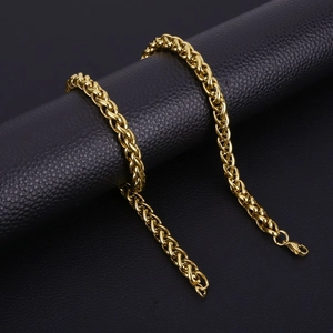 Detailed view of golden stainless steel dragon bone chain on black leather background