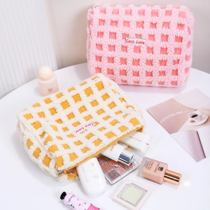 Large waffle plush makeup bags in pink and yellow checkerboard patterns for travel