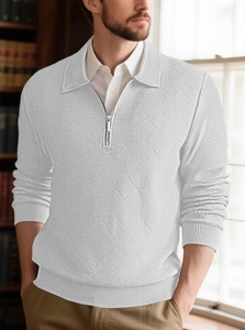 Close-up of white quarter-zip knit sweater showing detailed geometric diamond texture