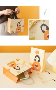 Detail of warm yellow teacher appreciation gift bags with elegant handles and creative illustrations