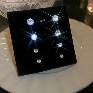 Five pairs of various sized magnetic zircon non-pierced stud earrings on black display
