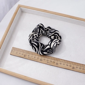 Chouchou minimaliste à motif zèbre noir et blanc en tissu doux sur plateau en bois