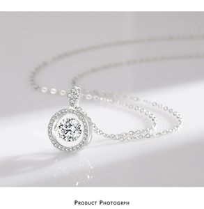 Macro shot of 925 silver necklace with a sparkling round zircon pendant on a white surface