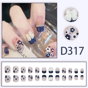 Press-on nails in navy blue French style with 3D bows, pearls, and small floral patterns