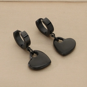 Detailed view of matte black heart-shaped pendant earrings with hoop buckles on wood