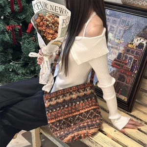 Close-up of bohemian geometric patterned knit tote bag in a warm festive home setting