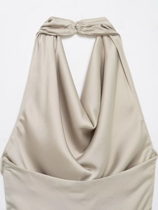 Détail du haut dos nu en satin champagne avec élégant col bénitier et texture soyeuse